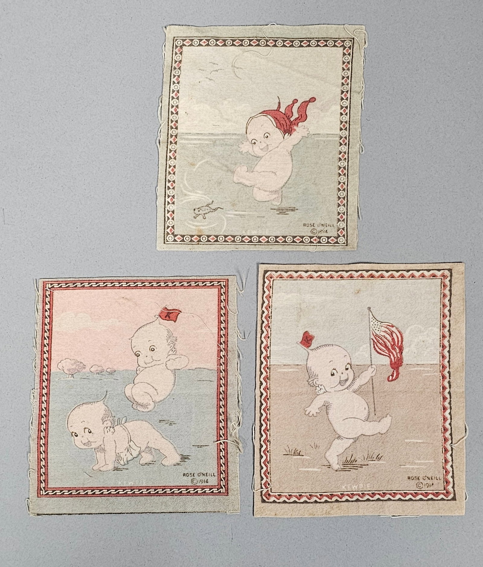Three Rose O'Neill Kewpie Tobacco Flannels: This set of three printed cotton panels features Kewpie characters designed by Rose O'Neill. Each panel bears a 1914 copyright mark and depicts varied scenes, including a Kewpie marching with an Ameri