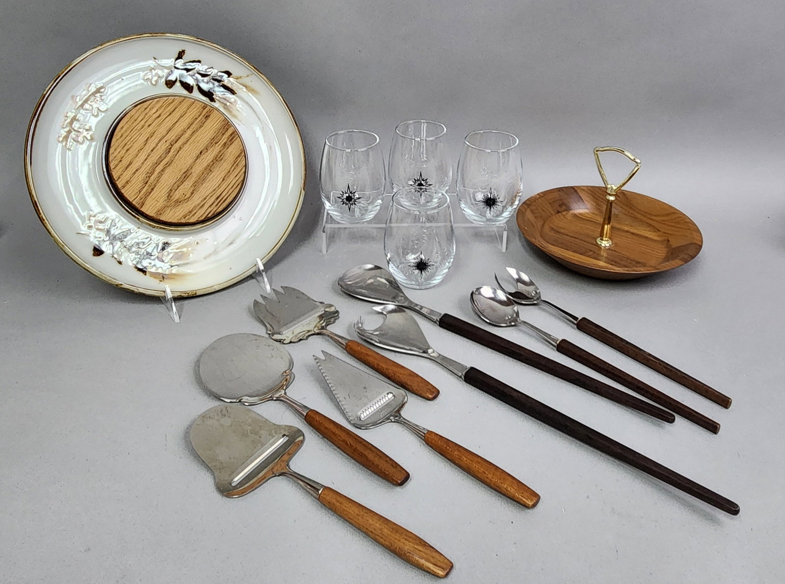 Mid-Century Modern Serving Collection: Including a collection of stainless steel serving utensils with tapered wooden handles includes items marked for Denmark and Norway. Platter diameter: 11.5 inches Tumbler height: 3.5 inches Utensil le