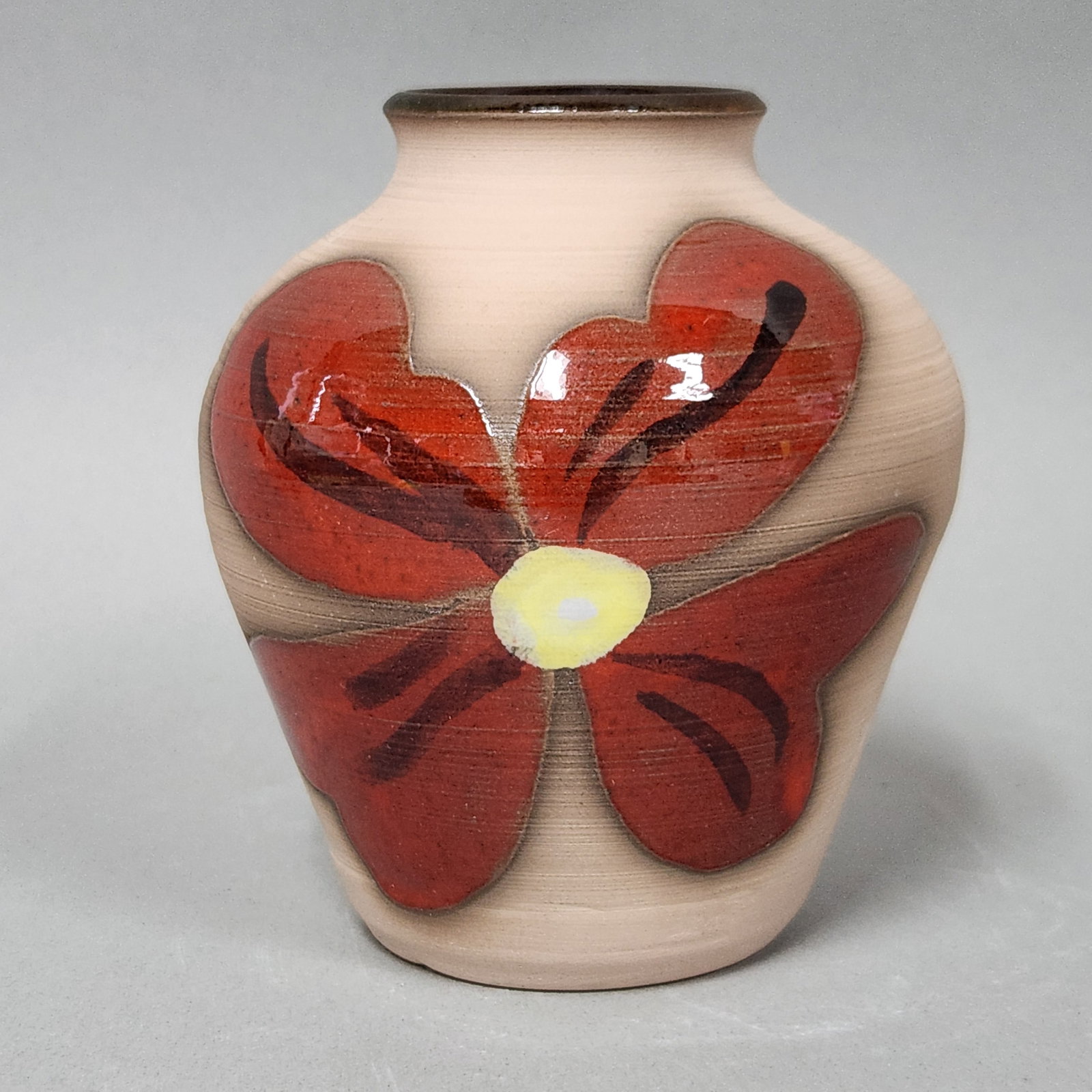 Kane Signed Floral Ceramic Vase: Studio pottery vase featuring a bold hand-painted floral motif in glossy red and yellow glazes. The base is signed Kane with a stylized K and includes a faint, illegible stamp. Height: 4.5 inches. Exc
