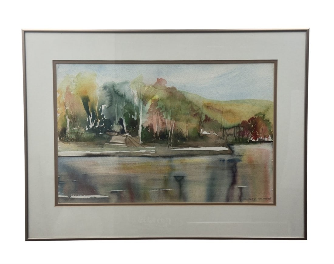 Shirley Talmadge Autumnal Landscape Watercolor: This original watercolor on heavyweight textured paper depicts an autumnal landscape with a screen of trees in shades of ochre and russet bordering a reflective body of still water. The composition