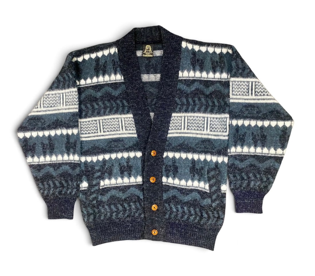 Tejidos Ruminahui Wool Llama Cardigan: This shawl-collar cardigan is hand-crafted by Tejidos Ruminahui in Otavalo, Ecuador, from wool with a high-loft brushed finish. The knit features horizontal bands of geometric motifs and stylized