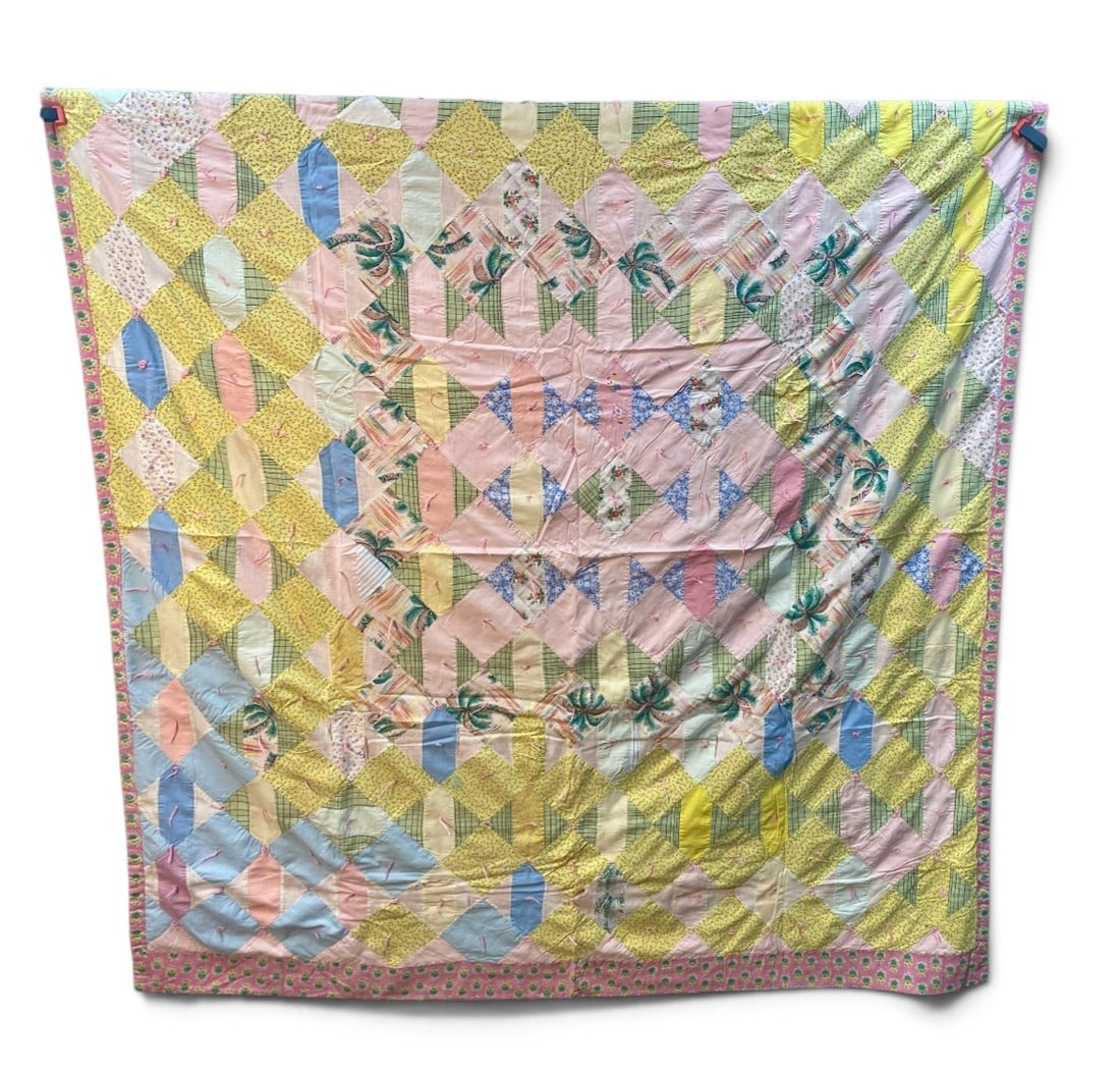 Mid-Century Hand-Pieced Spider Web Quilt: This hand-pieced and hand-tied cotton quilt features an intricate spider web pattern radiating from a central pink square. The design incorporates various mid-century novelty fabrics including