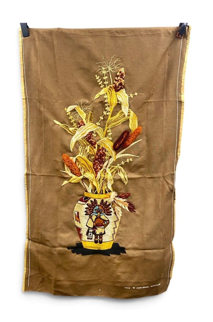 Sunset Designs Kachina Crewel Embroidery: This hand-worked crewel embroidery wall hanging was produced from a 1978 Sunset Designs kit, pattern number 2289. The composition features a Southwestern harvest arrangement of Indian corn and wheat