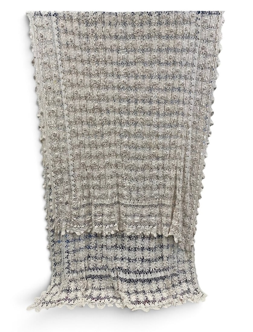 Large Hand Crocheted Floral Cotton Bedspread: This large-scale counterpane is hand-crocheted from heavyweight cream-colored cotton thread. The central field features repeating raised three-dimensional floral motifs set within a geometric mesh gri