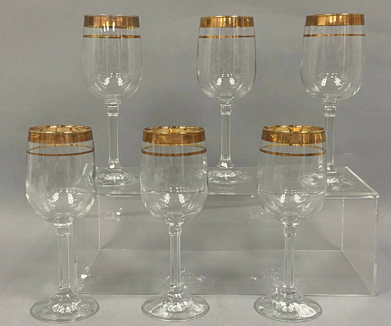 Set of Six Versailles Crystal Stemware: This set of six crystal wine goblets is produced in the Versailles pattern from Italy. Each vessel is decorated with double gold bands at the rim and features a faceted hexagonal stem with a circular