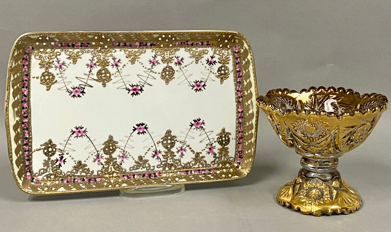 Nippon Tray and Gilded Glass Compote: The rectangular Nippon porcelain dresser tray features a reticulated border and handles, decorated with hand-painted floral swags and raised gilt scrolls. The pedestal compote is fashioned from presse