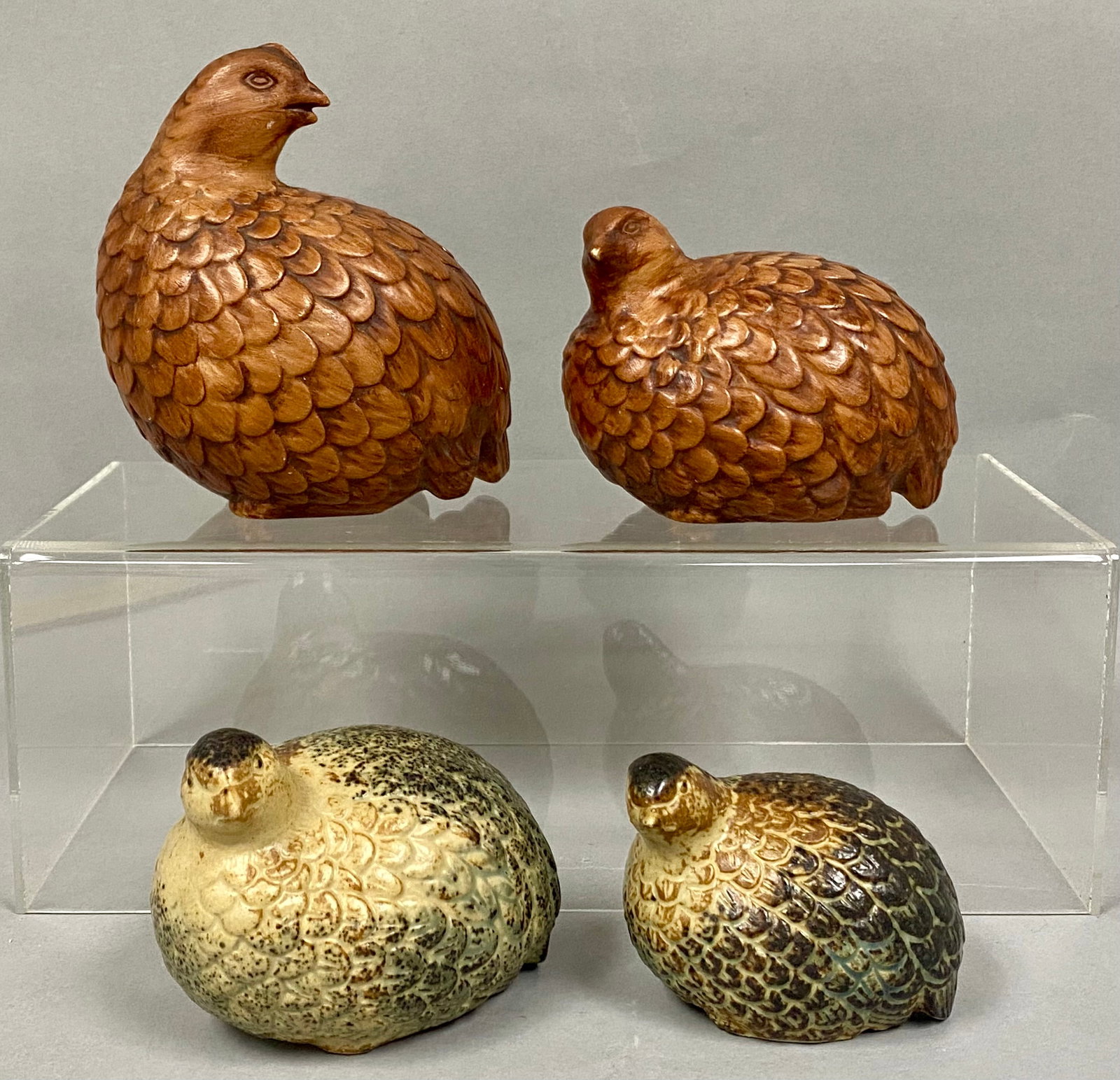 Assortment of Four Vintage Quail Figurines: An assortment of four vintage ceramic quail figurines featuring two distinct styles. One pair is finished with a reddish-brown glaze textured to simulate hand-carved wood and includes incised marks