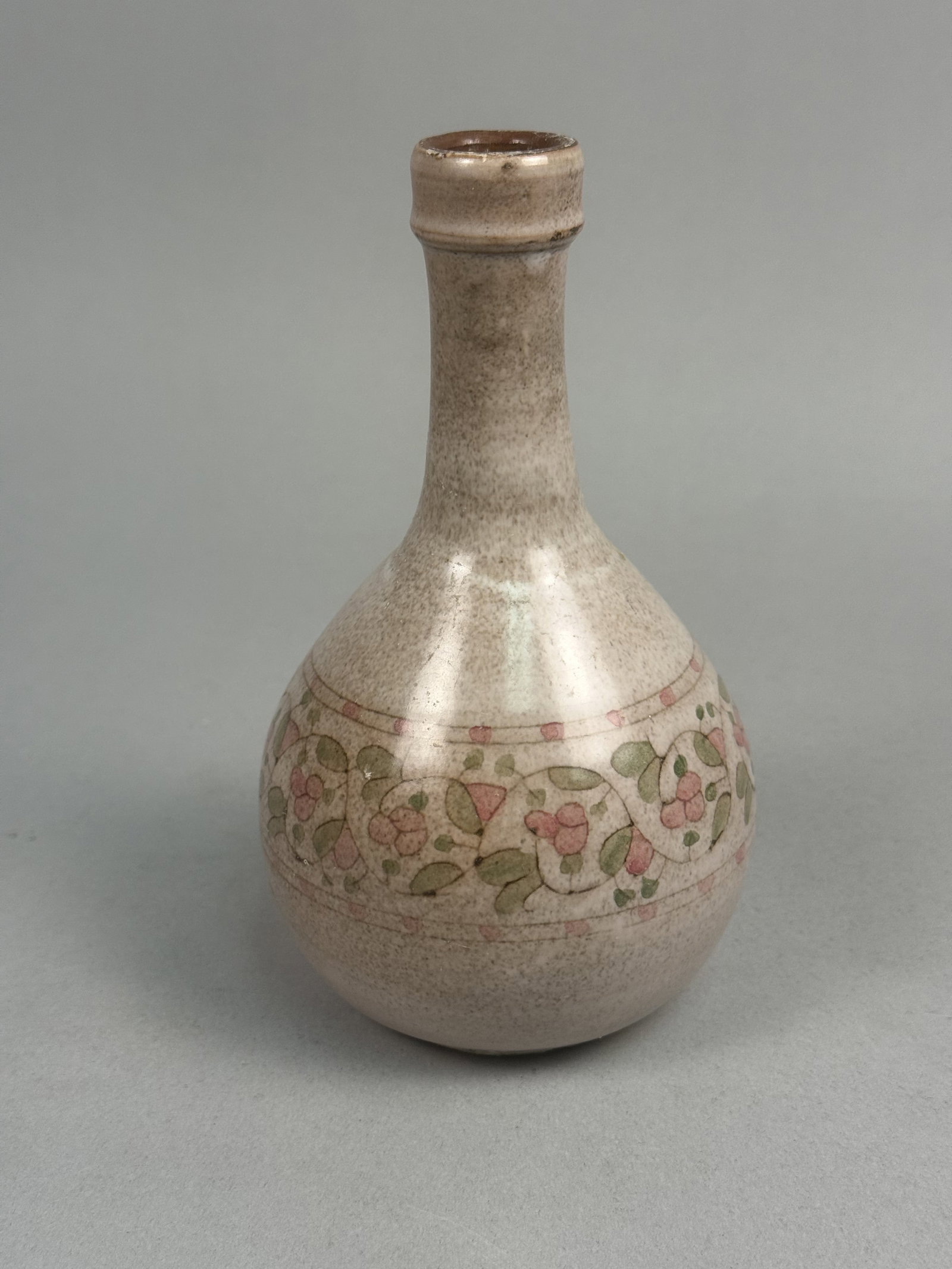 Dorothy Grimes Maine Pottery Vase: This studio pottery vase by Maine artist Dorothy Grimes features an onion-shaped body and a slender, flared neck. The stoneware piece is finished in a speckled light-grey glaze and decorated with a