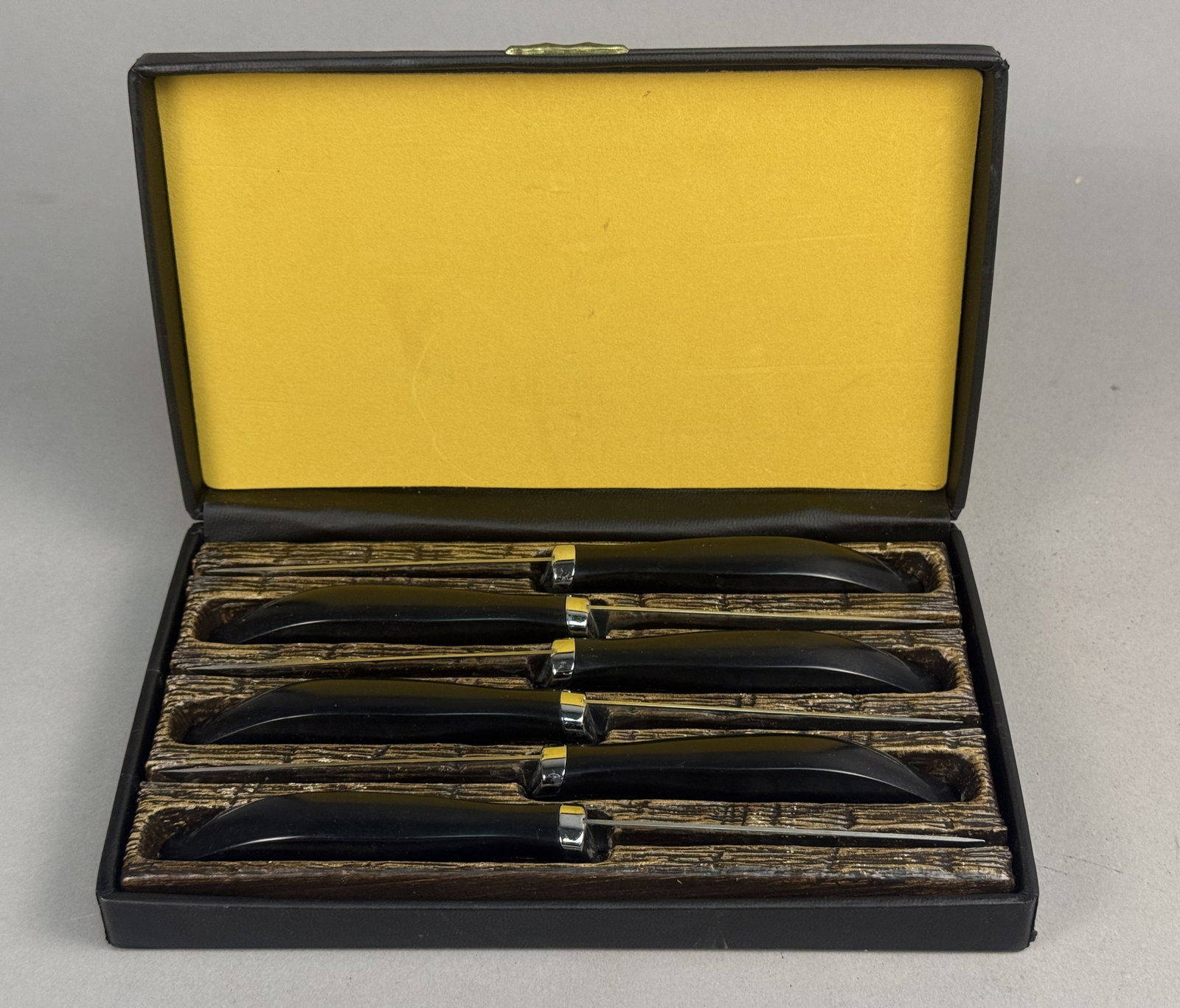 Six West Bend Steak Knives: A set of six West Bend steak knives featuring serrated stainless steel blades and contoured black synthetic handles. The blades are stamped Genuine West Bend Stainless Made in U.S.A. The collection