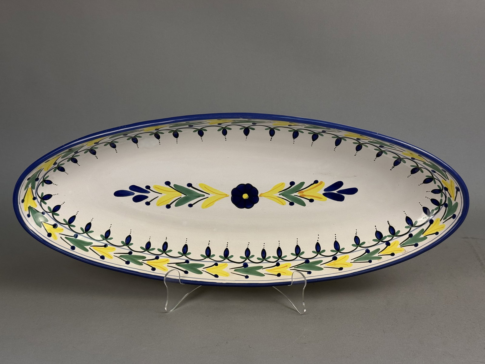 Le Souk Tunisia Hand-Painted Platter: This large Le Souk Ceramique serving platter is crafted from hand-painted earthenware with a white glazed ground. The elongated oval form features a central cobalt blue flower flanked by symmetrical