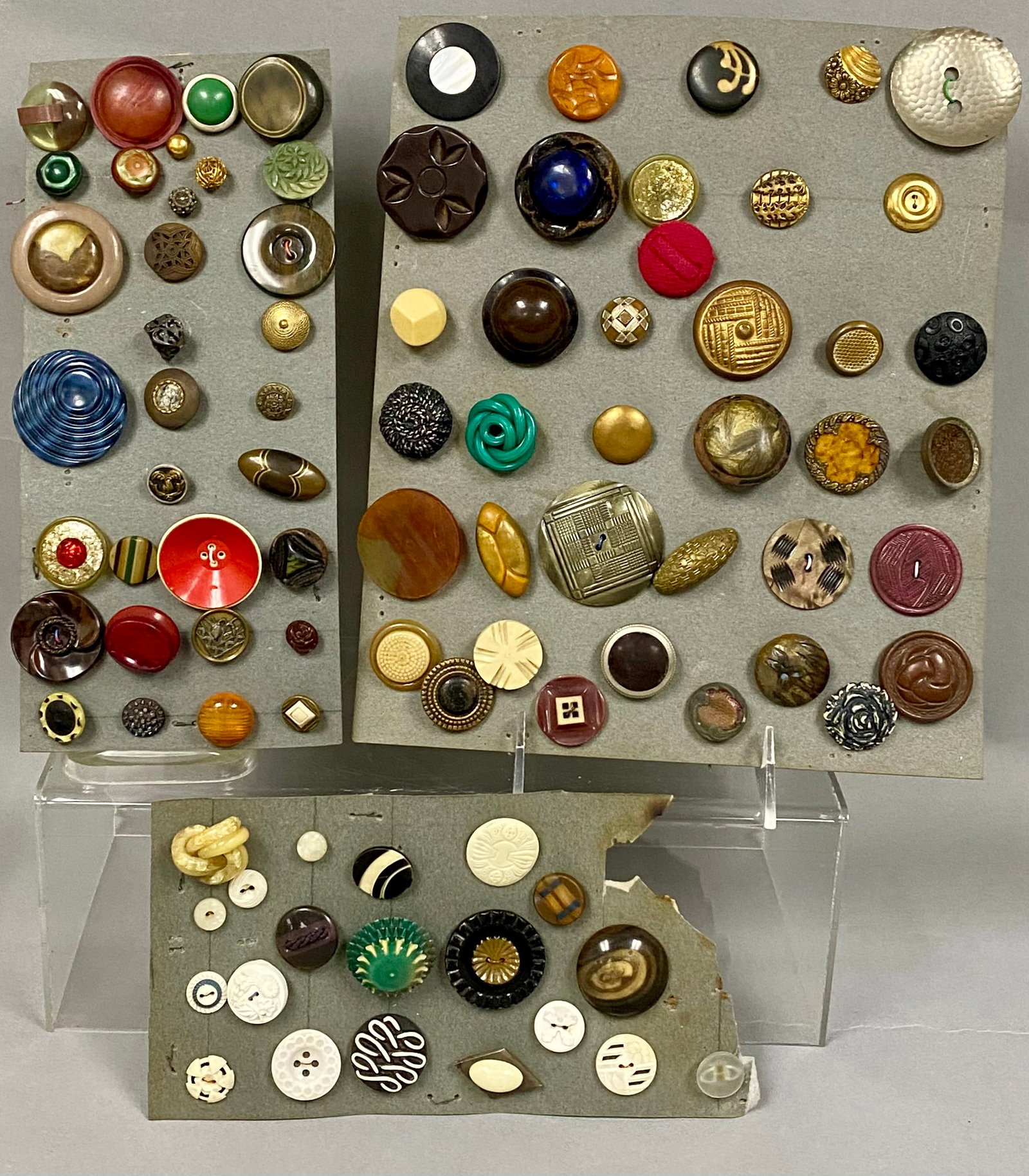 Collection of Antique and Vintage Buttons: A large collection of 90 vintage and antique buttons mounted on three display cards, featuring styles from the late 19th through the mid-20th century. The assortment includes a variety of materials su
