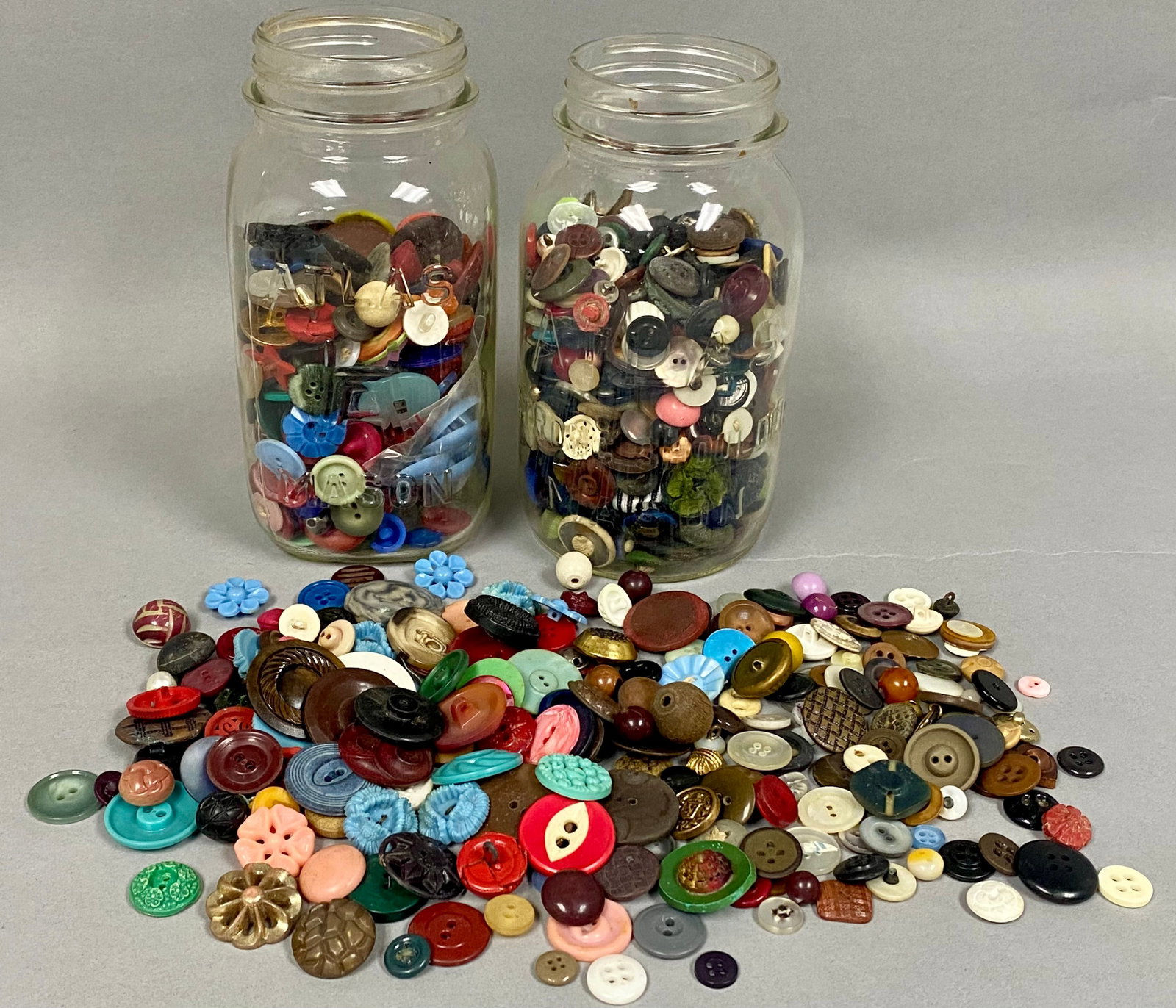 Two Atlas Mason Jars of Vintage Buttons: An expansive assortment of vintage and modern sewing buttons composed of various materials including plastic, glass, metal, mother-of-pearl, and wood. The collection features a wide range of styles su