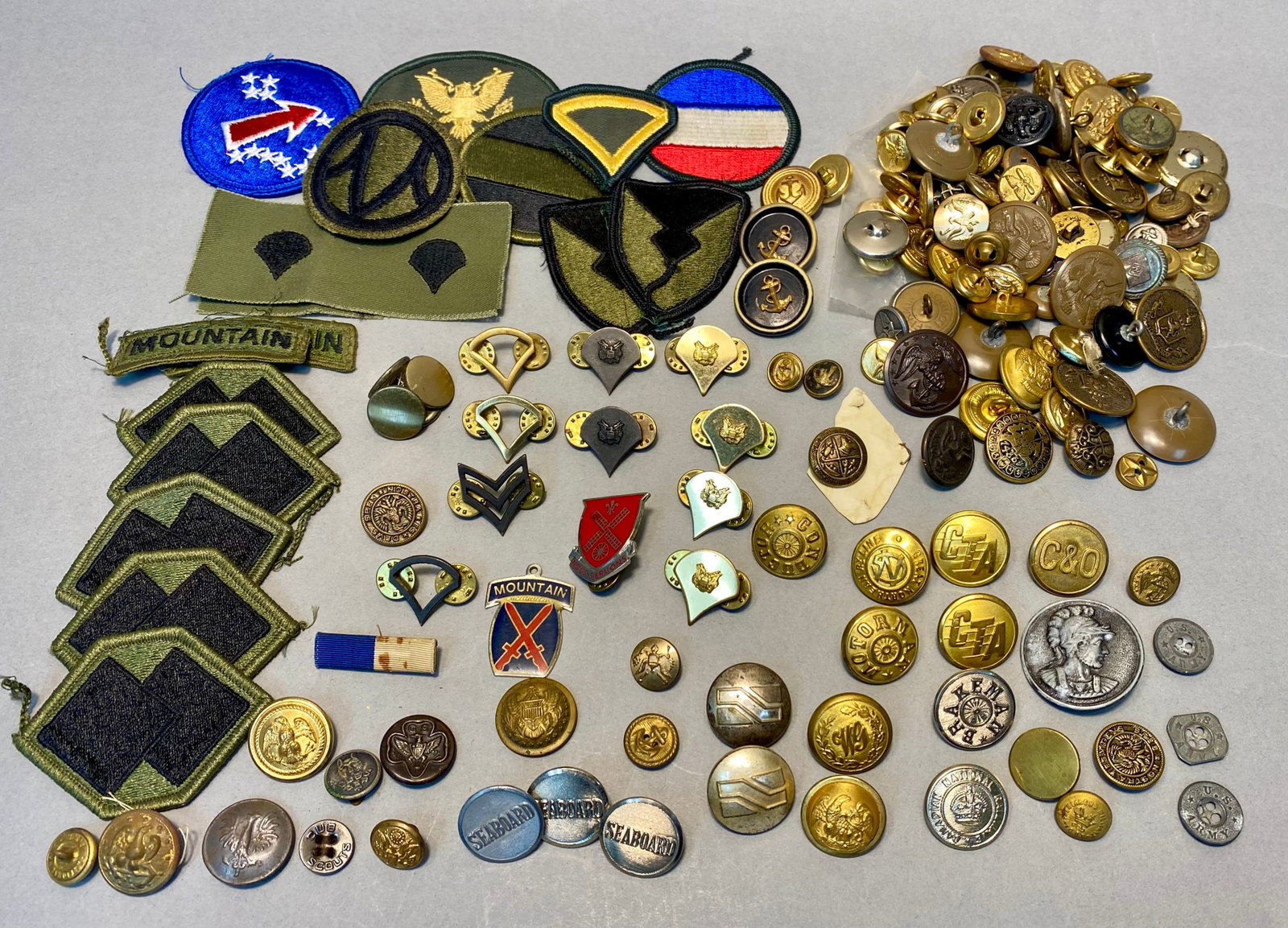 Military and Transit Insignia Collection: This collection features United States military, railroad, and scouting insignia, including items from the 10th Mountain Division and 14th Engineer Battalion. The assortment consists of embroidered fa
