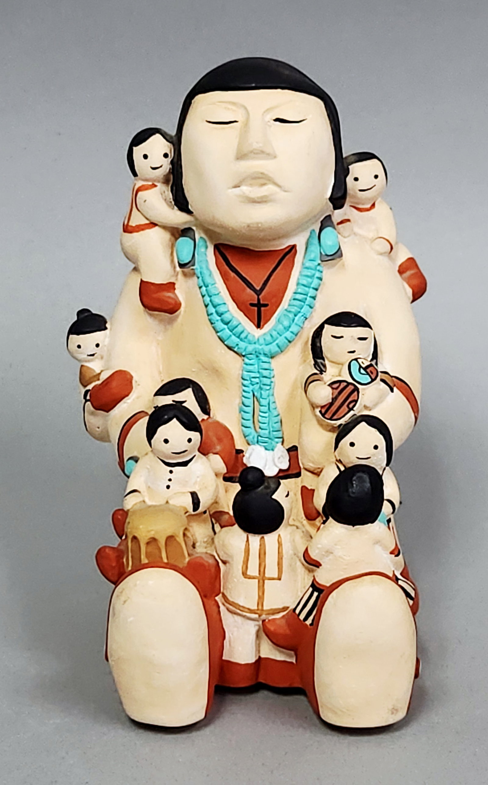 Cleo Teissedre Storyteller Figurine: A Cleo Teissedre hand-painted ceramic storyteller figurine dated 1986. Height: 4.25 inches; Width: 3 inches. A horizontal surface fissure is visible across the middle back of the primary figure. The p