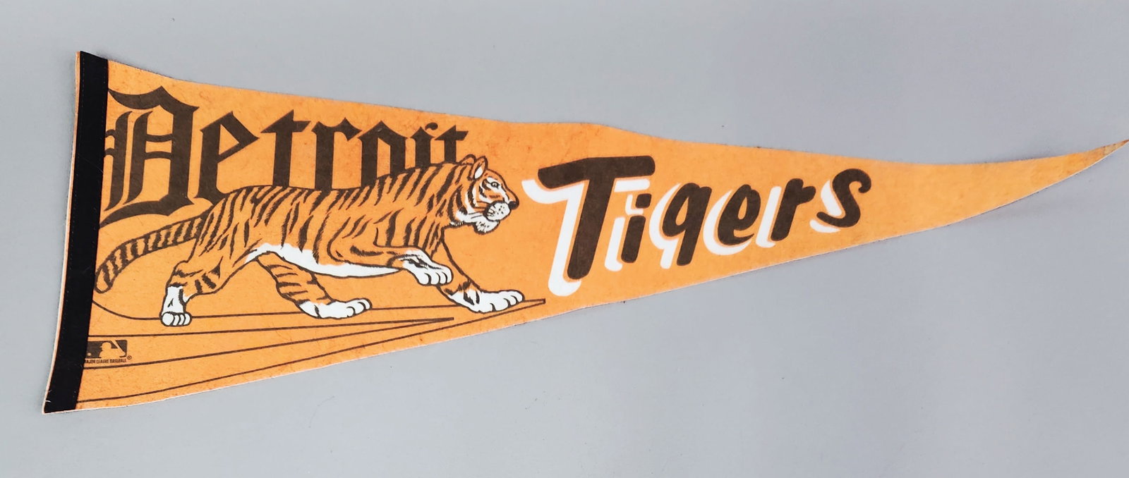 Vintage Detroit Tigers Baseball Pennant: This full-size triangular orange felt pennant features a central walking tiger graphic between the words Detroit in a black Gothic-style font and Tigers in a script font. Height: 11 inches. Very good