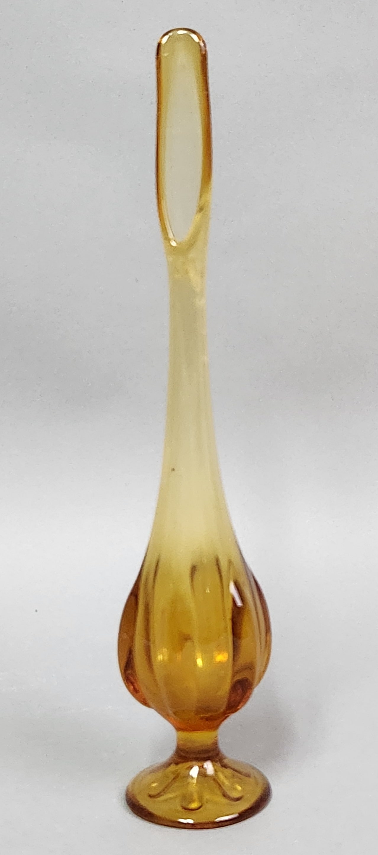 Viking Amber Swung Glass Vase: This Viking Glass Company swung vase is crafted from transparent amber glass with a vertically ribbed lower body. Height: 13.75 inches. Good vintage condition with no visible chips, cracks, or repairs