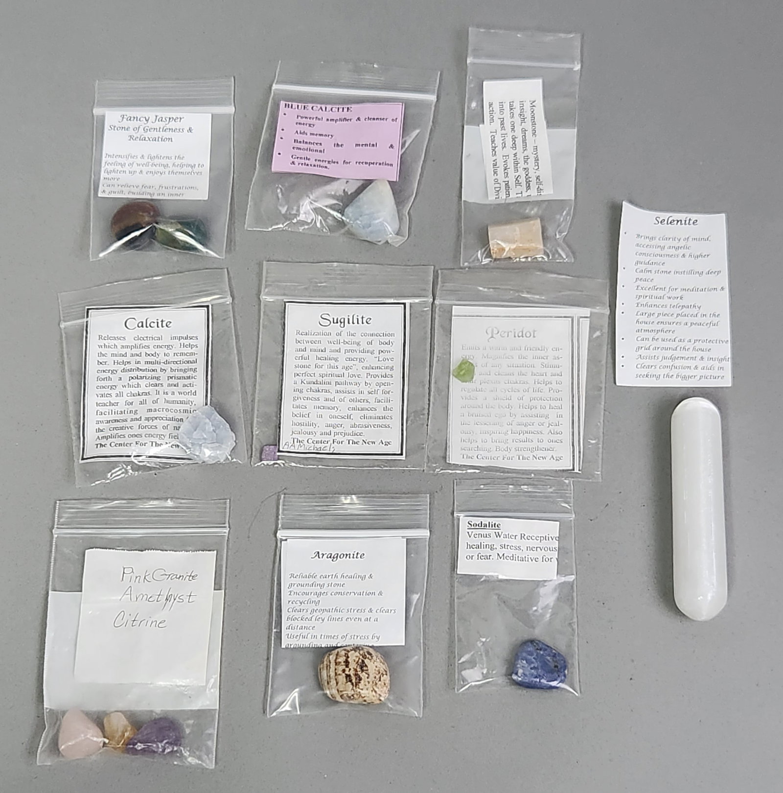 Gemstone & Mineral Specimen Collection: The collection features a variety of species including a polished selenite wand, blue calcite, sugilite, aragonite, sodalite, peridot, fancy jasper, moonstone, amethyst, citrine, and pink granite.
