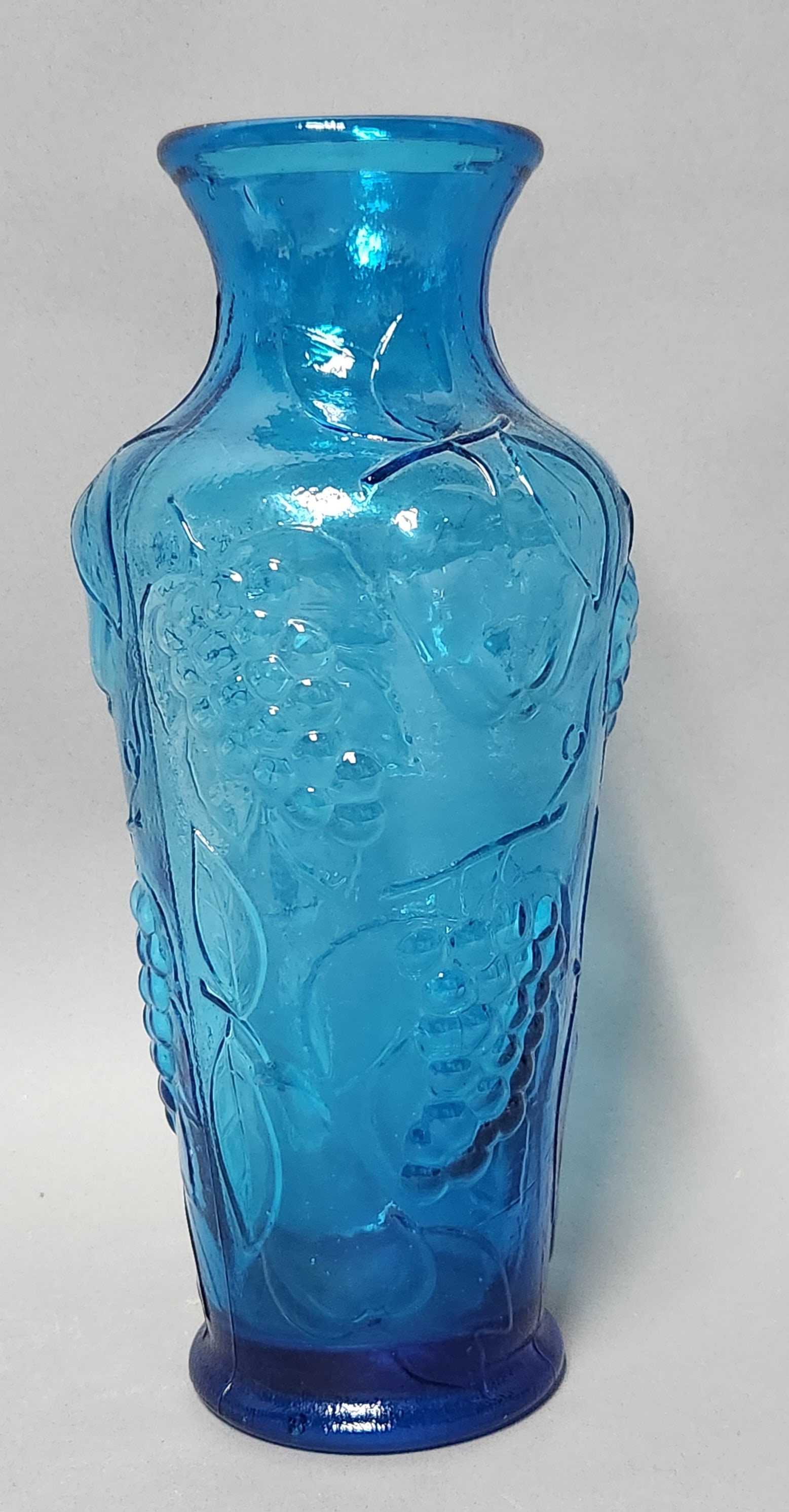 Empoli Blue Glass Fruit Vase: This mid-century Empoli blue glass vase features an embossed relief pattern depicting grapes, apples, and vines. Height: 12.5 inches (31.75 cm). Excellent condition with no visible chips, cracks, or r