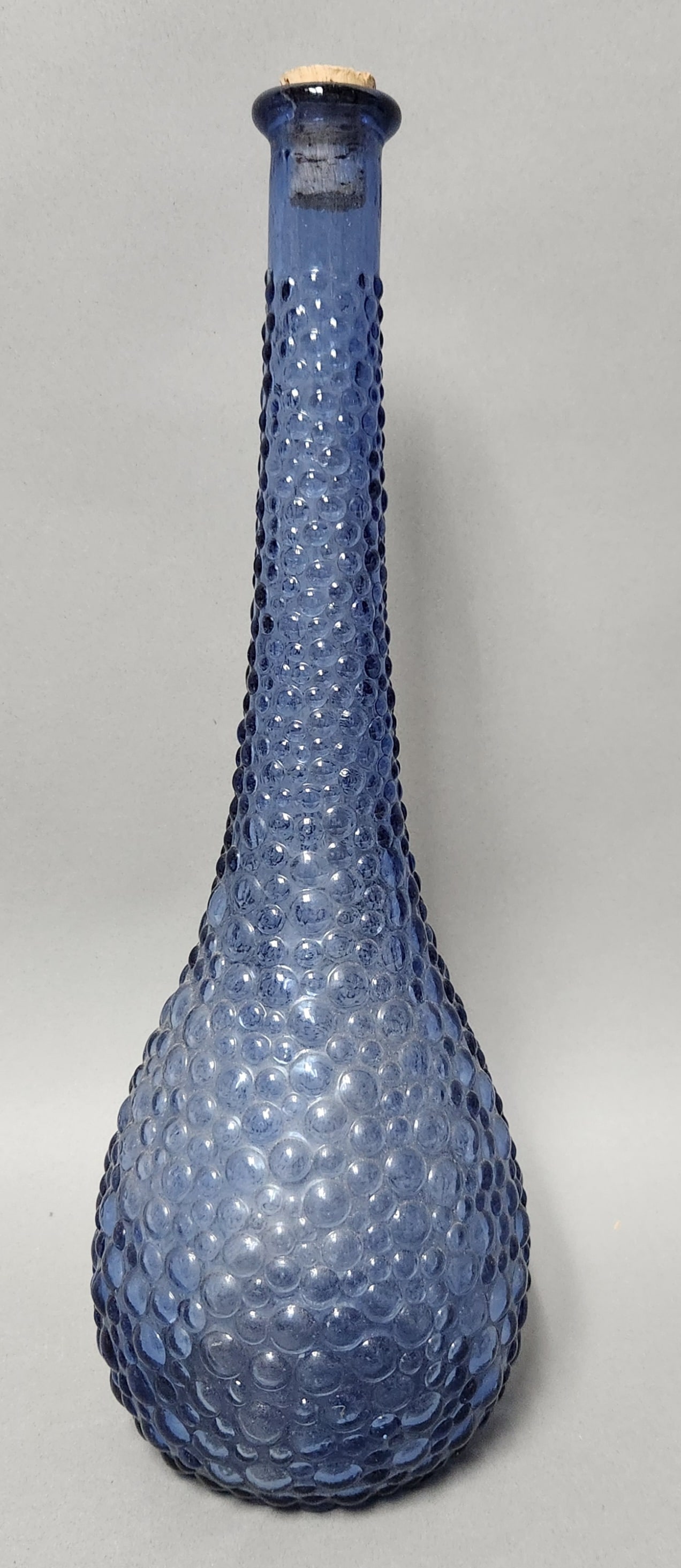 Empoli Blue Glass Bubble Decanter: A mid-century modern cobalt blue glass bottle from the Empoli region of Italy featuring an all-over raised bubble texture. Height: 15 inches. This piece is in good vintage condition with no chips, cra