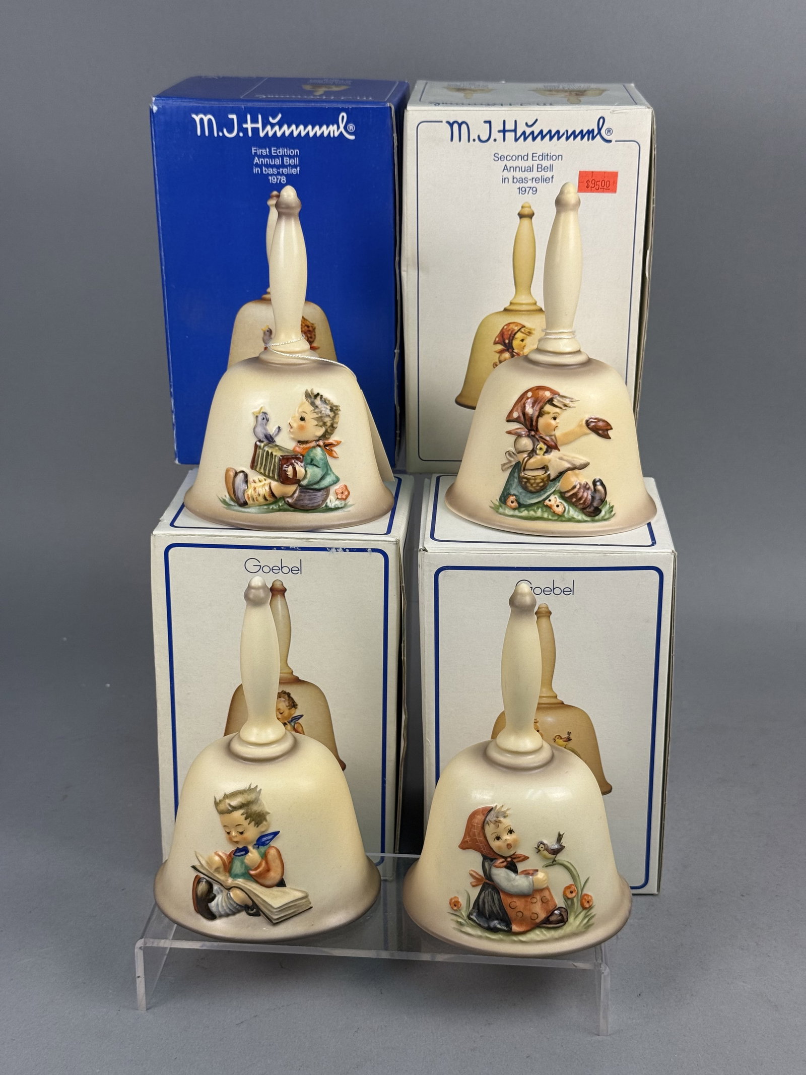 Four Goebel Hummel Annual Bells: This set of four hand-painted porcelain annual bells by Goebel features bas-relief Hummel figures produced between 1978 and 1981. The collection includes the first through fourth editions, each depict