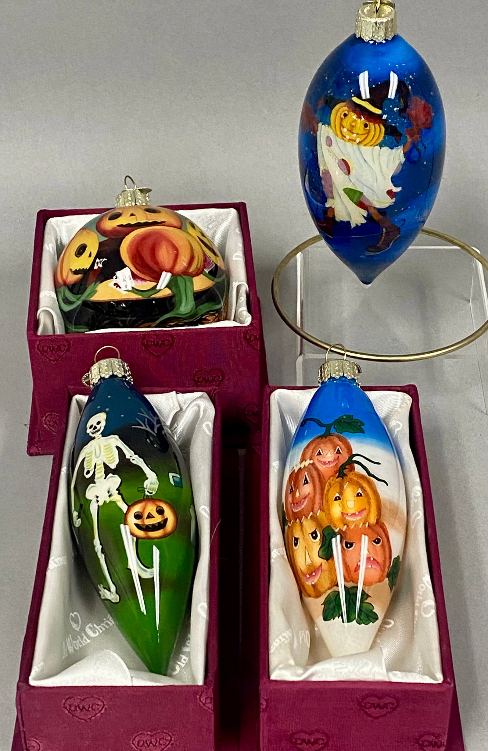 Set of Four Old World Christmas Halloween Ornaments: A set of four Old World Christmas hand-blown glass ornaments featuring various Halloween scenes rendered in the Li Bien reverse-painting technique. The collection includes Pumpkin Scarecrow, Poker Pum