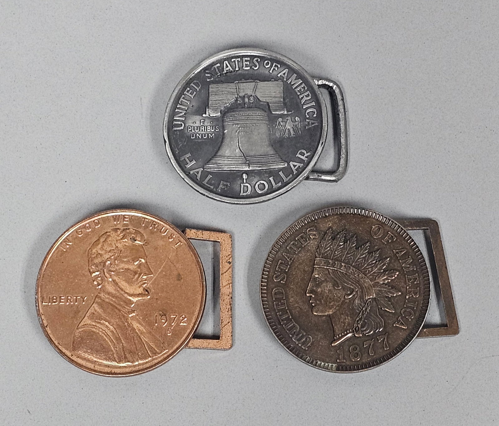 A Trio of Vintage Coin Buckles: This trio of cast metal belt buckles by Coin Buckle of Southfield, Michigan, features enlarged replicas of historic United States currency. The set includes a copper-toned 1972-S Lincoln cent, a