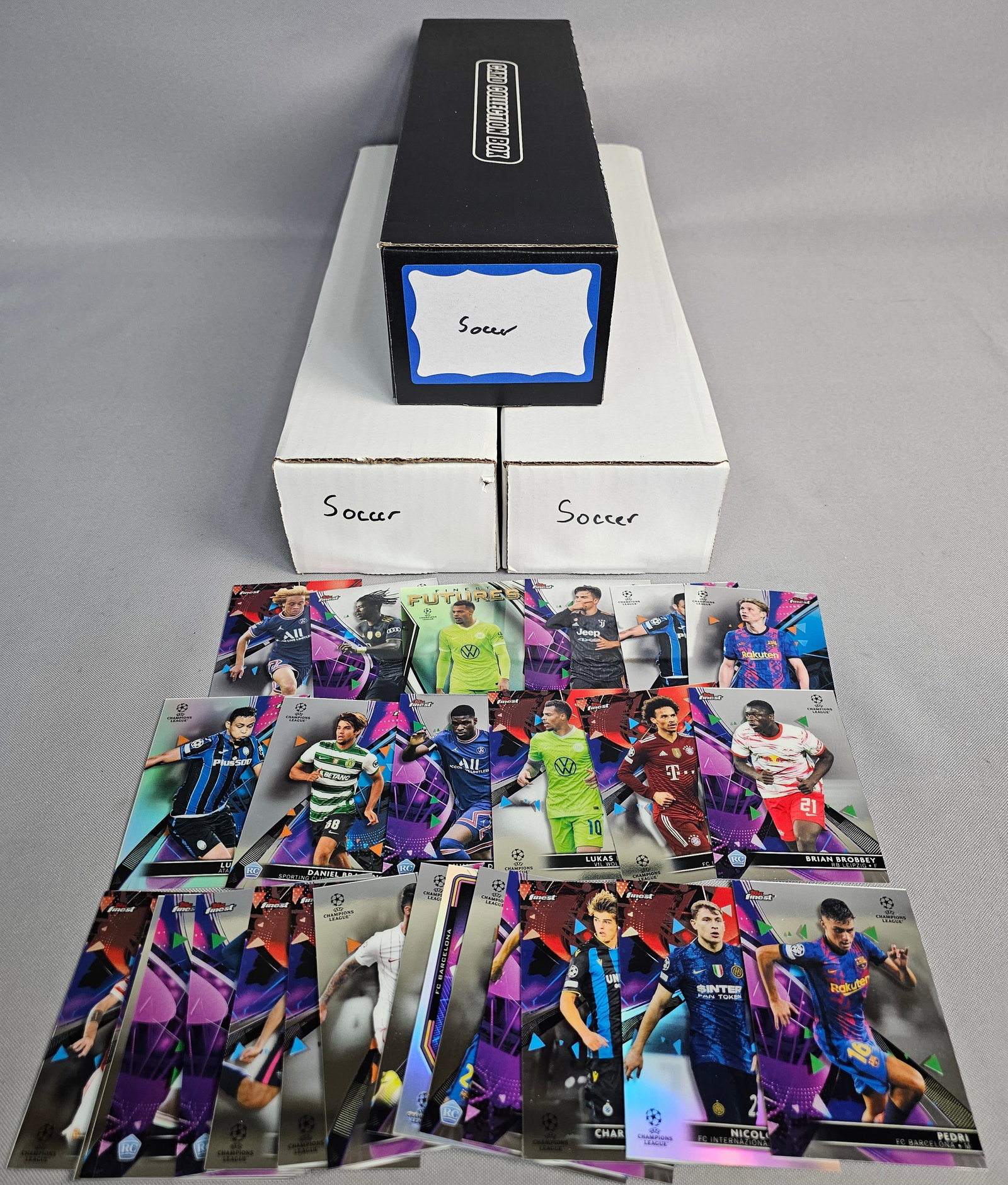 Large Soccer Trading Card Collection: An extensive collection of soccer trading cards comprising modern Topps Finest UEFA Champions League, Panini Prizm Premier League, and 2018 World Cup tournament issues. The lot features various