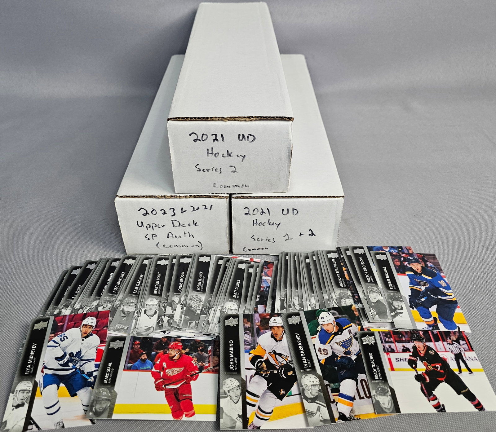 Bulk Collection Upper Deck NHL Cards: The lot comprises base cards from flagship Series 1 and 2 along with SP Authentic sets, featuring notable players including Connor McDavid and Sidney Crosby. All cards are housed within three labeled