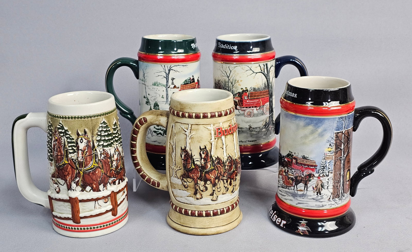 A Collection of Budweiser Holiday Steins: This collection features five ceramic beer steins handcrafted by Ceramarte in Brazil for the Budweiser holiday series. The set includes the 1980 and 1981 relief-decorated editions along with the