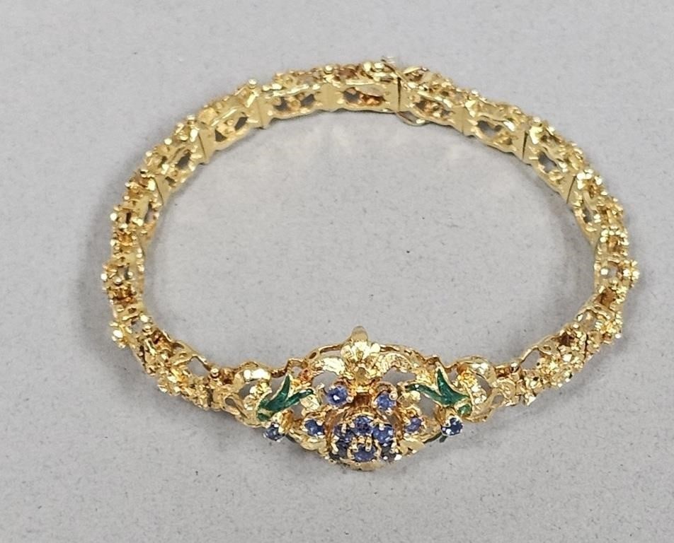 14K Sapphire & Enamel Bracelet 23.5 Grams: The bracelet is 14K yellow gold and the clasp is 18K White Gold. A vintage-style yellow gold bracelet featuring an ornate central openwork motif in a floral and foliate design. The center of the