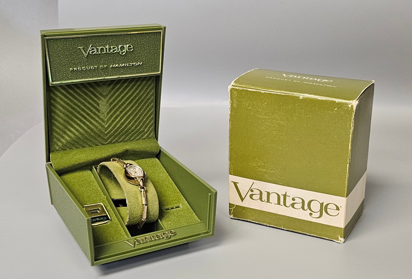 Vintage Boxed Vantage Ladies Dress Watch: This mid-century Vantage ladies dress watch features a seventeen-jewel manual wind movement housed in a gold-tone base metal bezel with a stainless steel back. The silver-tone dial is marked Vantage 1