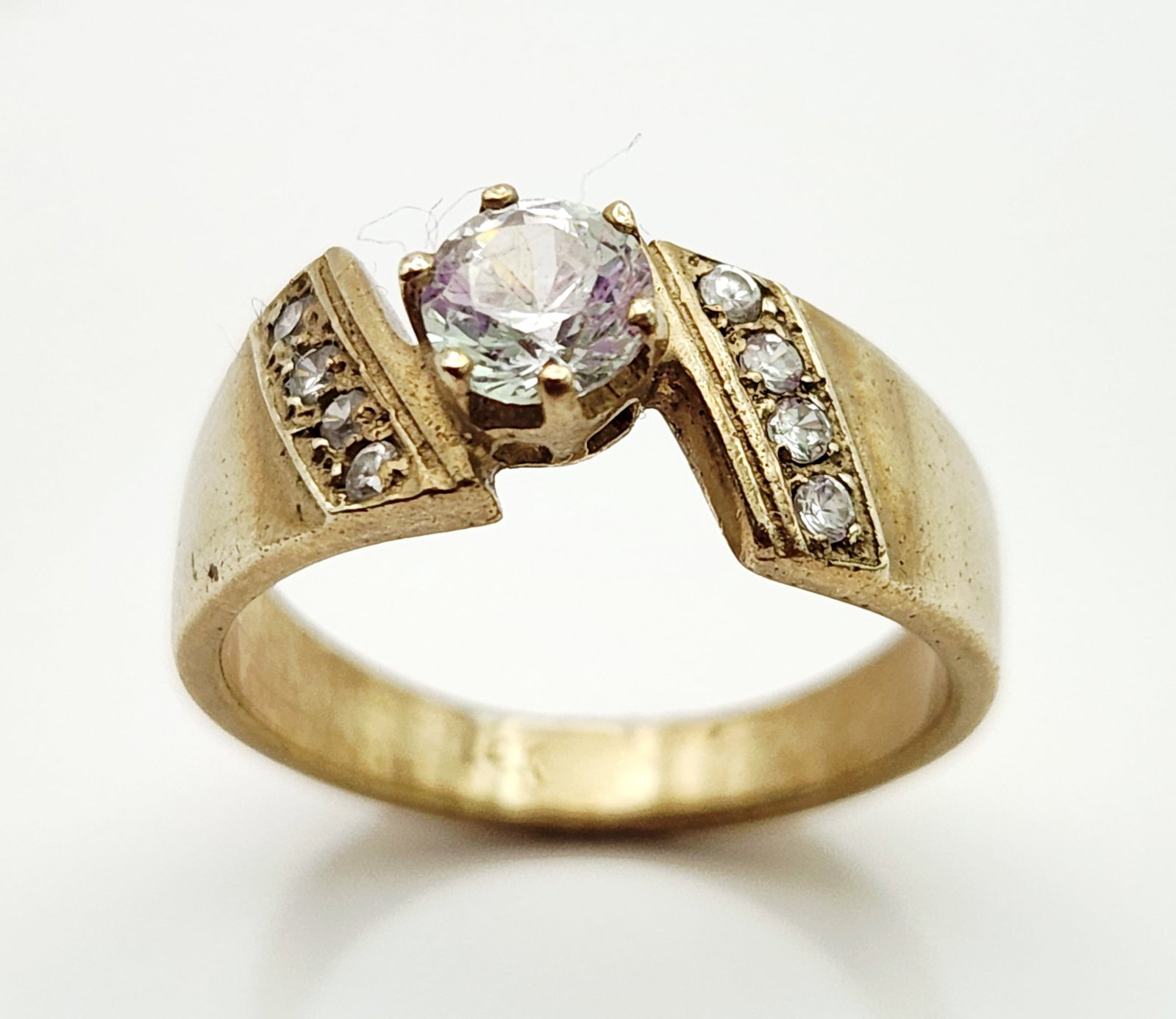 14K Gold Bypass CZ Ring 3.6 Grams: A 14 karat yellow gold bypass ring featuring a central round brilliant-cut cubic zircona secured in a four-prong head. Weighing 3.6 grams and measuring size 6.75, the piece is stamped 14K on the inter