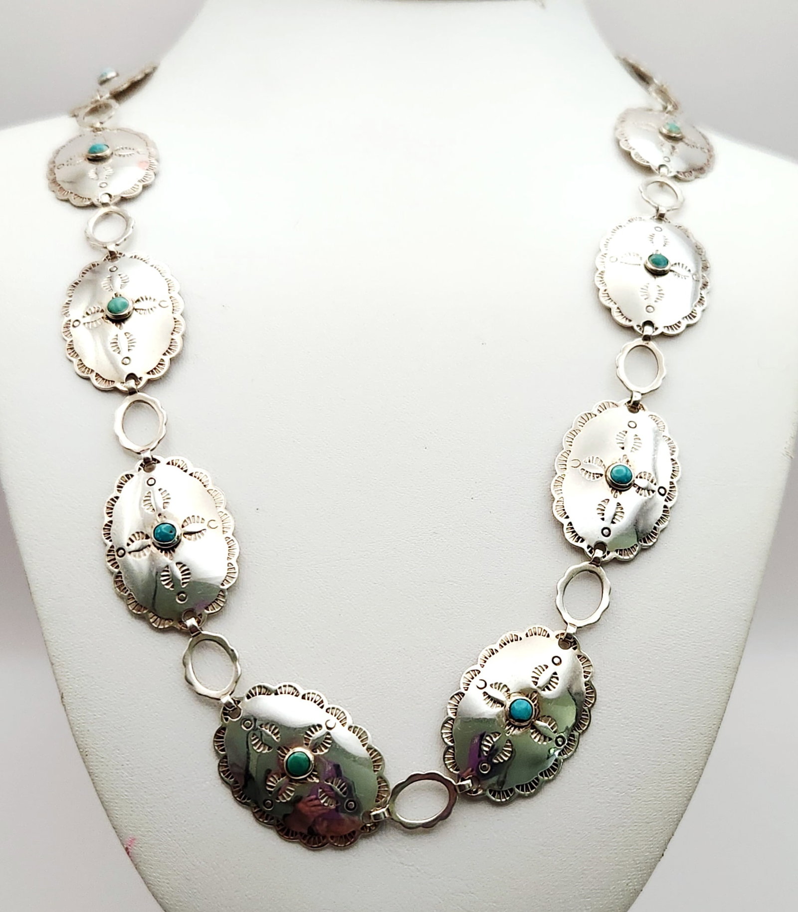 Bell Trading Post Turquoise Concho Belt 77.9 Grams: This mid-century Southwestern link belt/necklace features thirteen stamped oval conchos and a rectangular buckle, each set with a turquoise cabochon in sterling silver. The piece is identified by the 