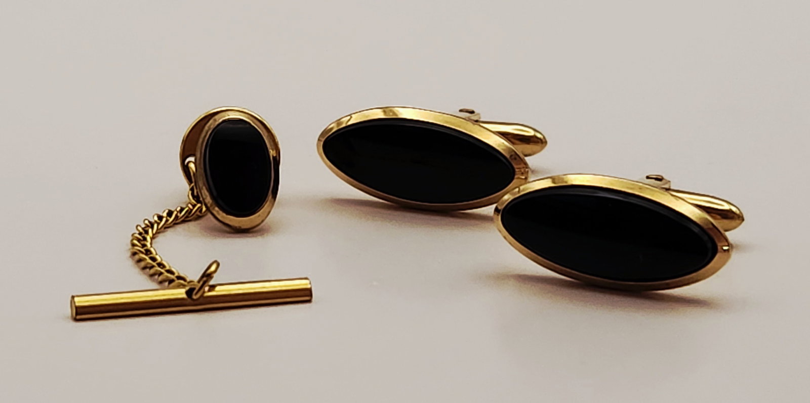 Gold-Filled Onyx Cufflinks & Tie Tack: This three-piece set features toggle-back cufflinks and a coordinating tie tack set with oval black cabochons in gold-filled mounts. Each piece is impressed on the reverse with 1/20 14K G.F. Fine