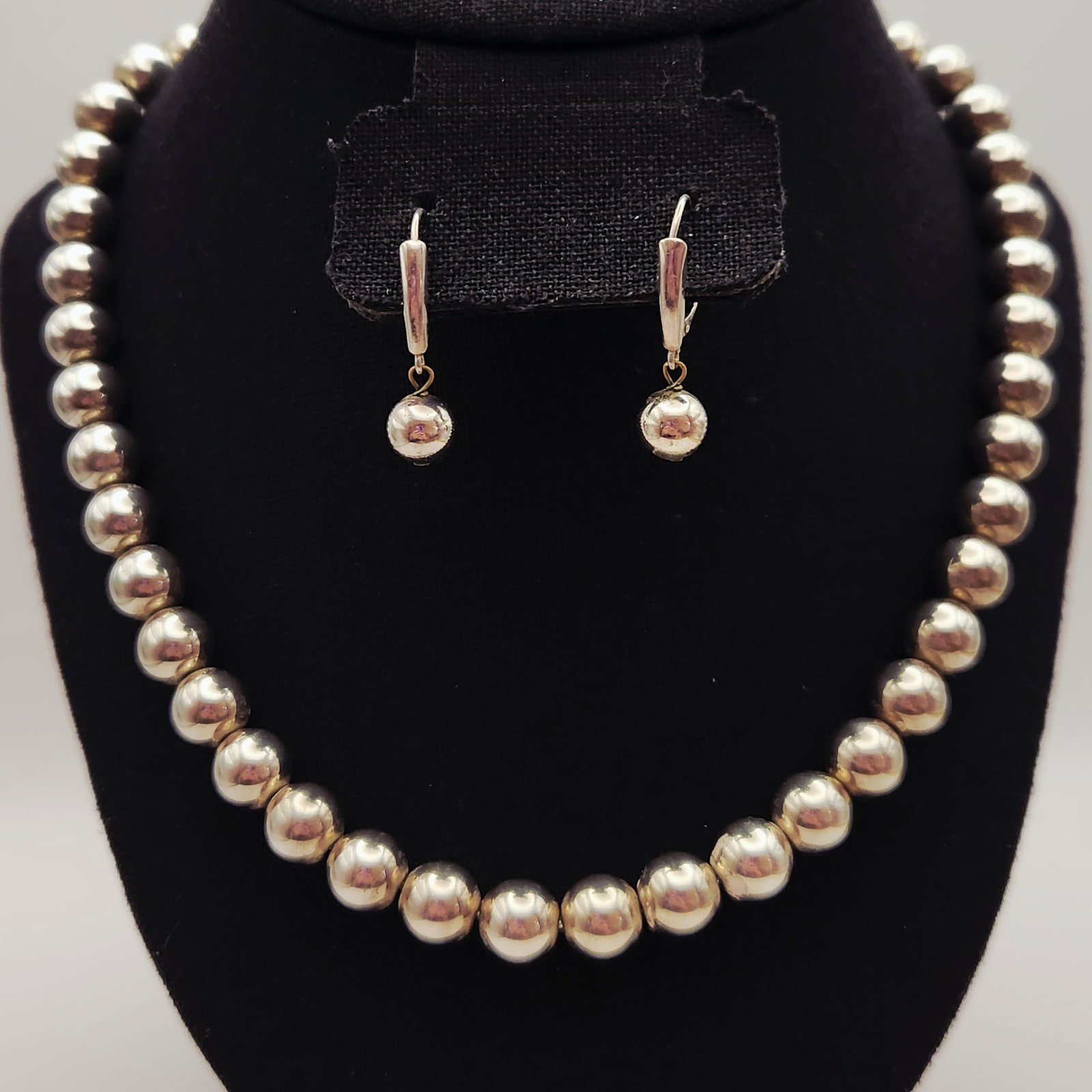 Tiffany & Co. Sterling Bead Set 54.3 Grams: This two-piece jewelry set by Tiffany & Co. is crafted in polished sterling silver and includes a sixteen-inch graduated bead necklace with matching drop earrings. Each piece features hollow