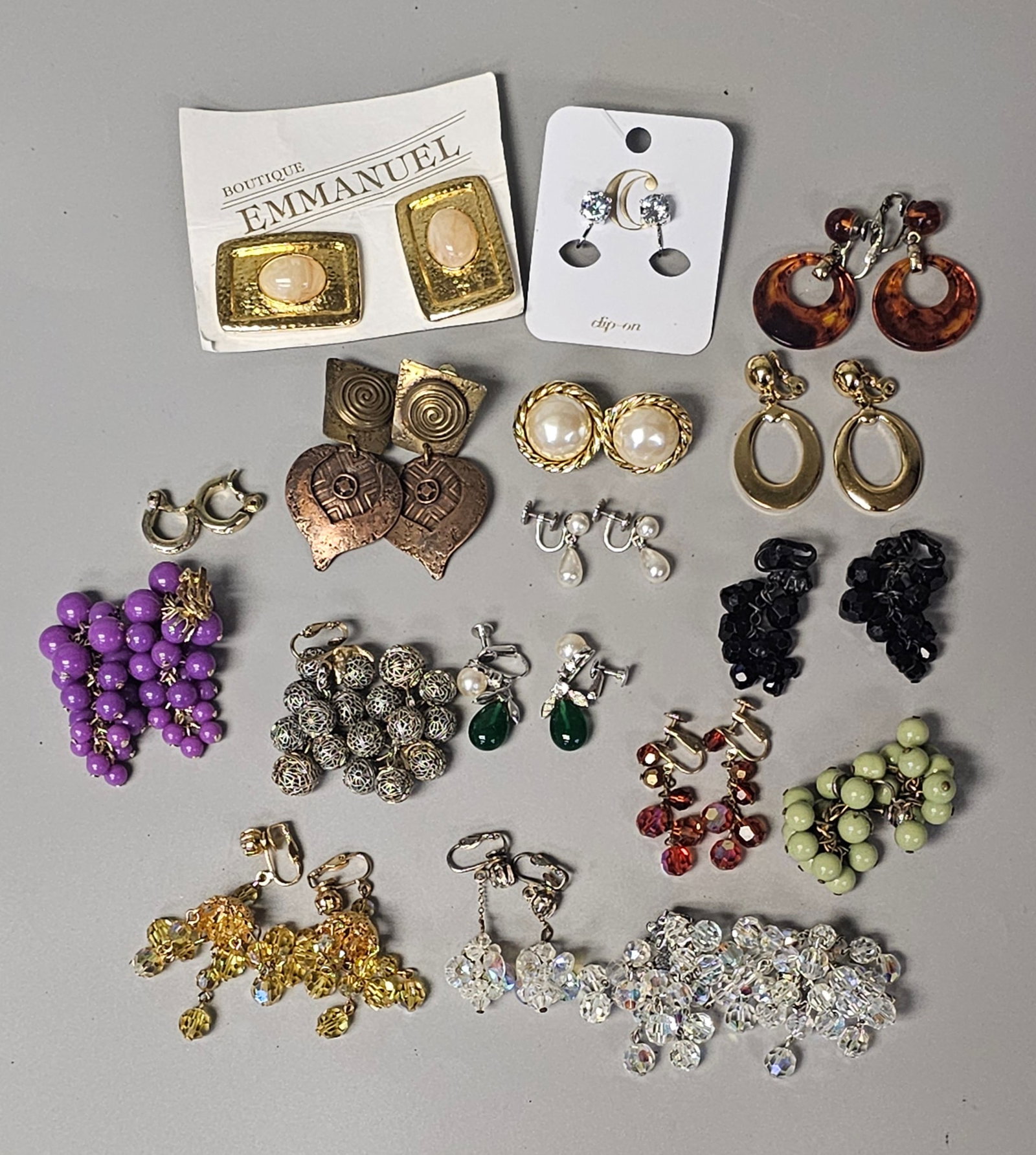 Vintage Costume Earring Collection: A collection of vintage costume earrings. Materials comprise base metal, faceted glass beads, faux pearls, and resin. Individual earrings range in length from 0.5 inches to 3 inches; the entire lot me