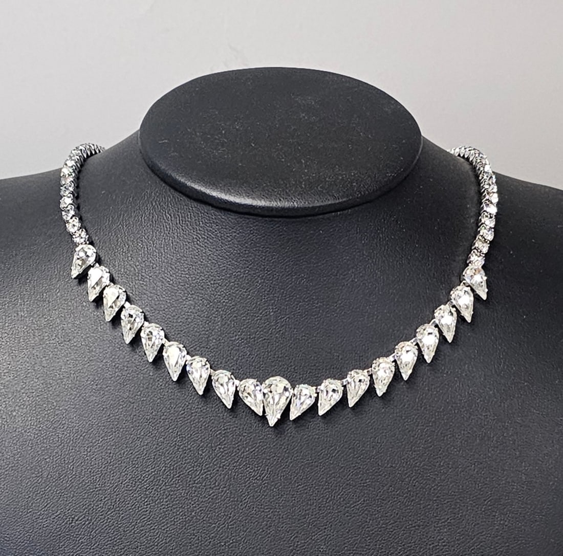Weiss Graduated Crystal Fringe Necklace: A vintage silver-tone fringe necklace featuring a graduated arrangement of clear faceted glass crystals. The central section is composed of prong-set pear-shaped stones that transition into a chain