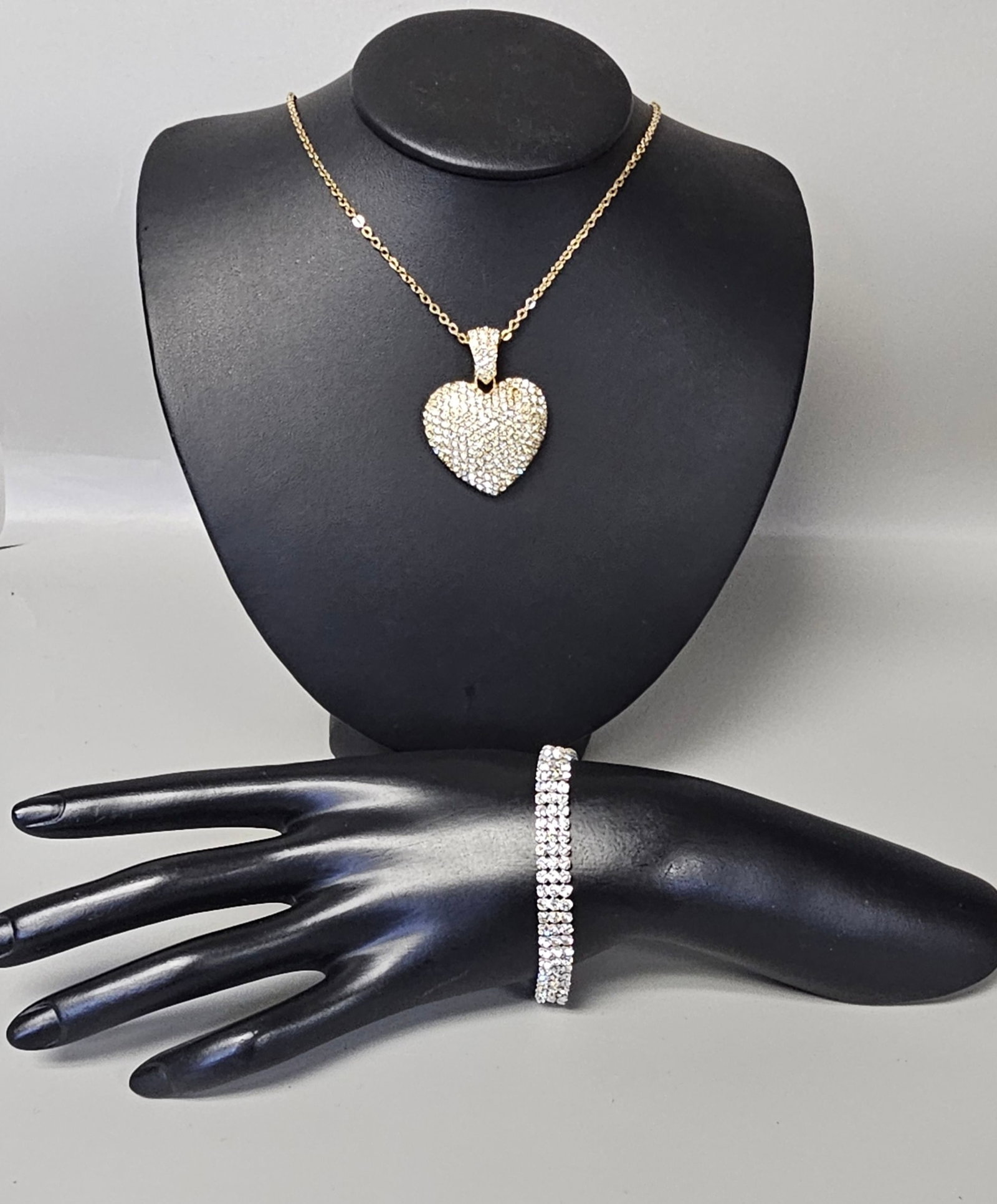 Two Swarovski Crystal Jewelry Pieces: This jewelry lot includes a Swarovski gold-tone necklace with a pave-set crystal heart pendant and a silver-tone three-row crystal tennis bracelet. The necklace features a lobster claw clasp Necklace 