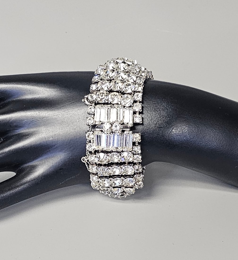 Kramer of New York Rhinestone Bracelet: A wide silver-tone costume bracelet featuring multiple rows of prong-set clear rhinestones. The design consists of four outer rows of round stones flanking two central rows of vertically-set