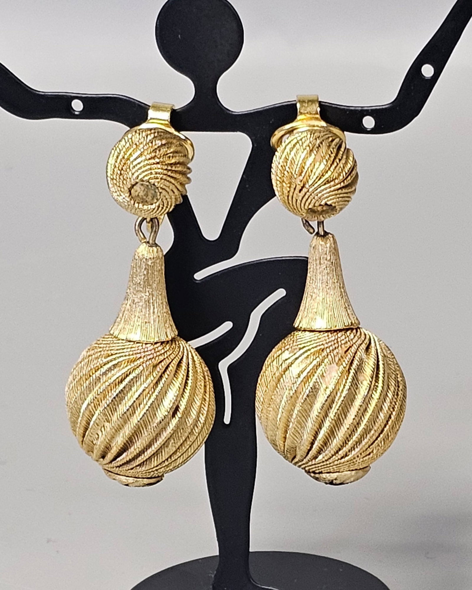 Vintage Trifari Textured Drop Earrings: A pair of vintage gold-tone drop earrings by Trifari, designed with a textured, diagonal rope-twist finish across two articulating sections. Total length: 2.25 inches This matched pair is in good vint
