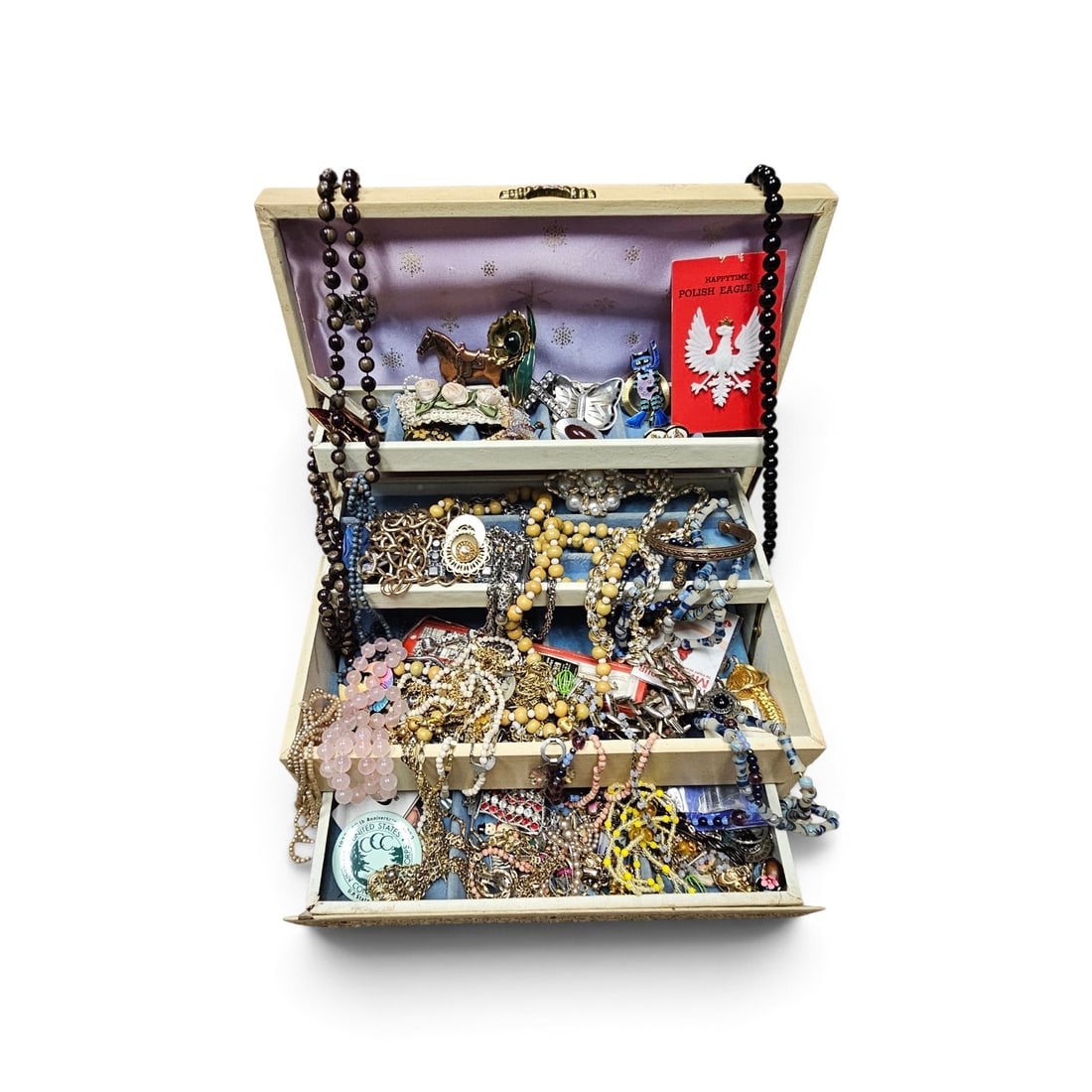 Assorted Vintage Costume Jewelry and Pins: This collection of mid to late 20th-century costume jewelry is presented in a three-tier cantilever chest with gold-tone floral accents. Items not inspected.