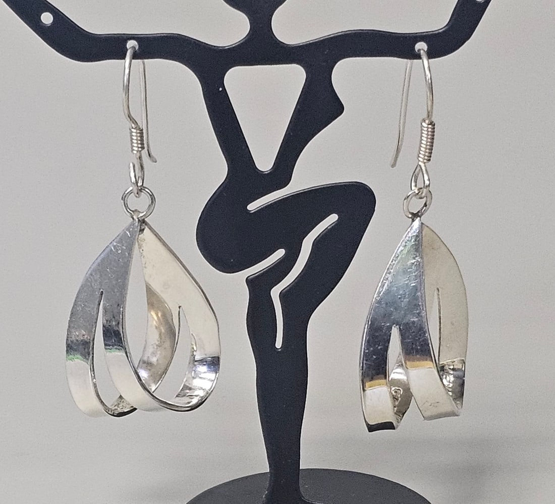 Mexican Sterling Silver Drop Earrings 9.7 Grams: A matched pair of Mexican sterling silver drop earrings featuring a sculptural, openwork twisted teardrop design. Each pendant is suspended from a French wire hook with a coil and loop detail. Total