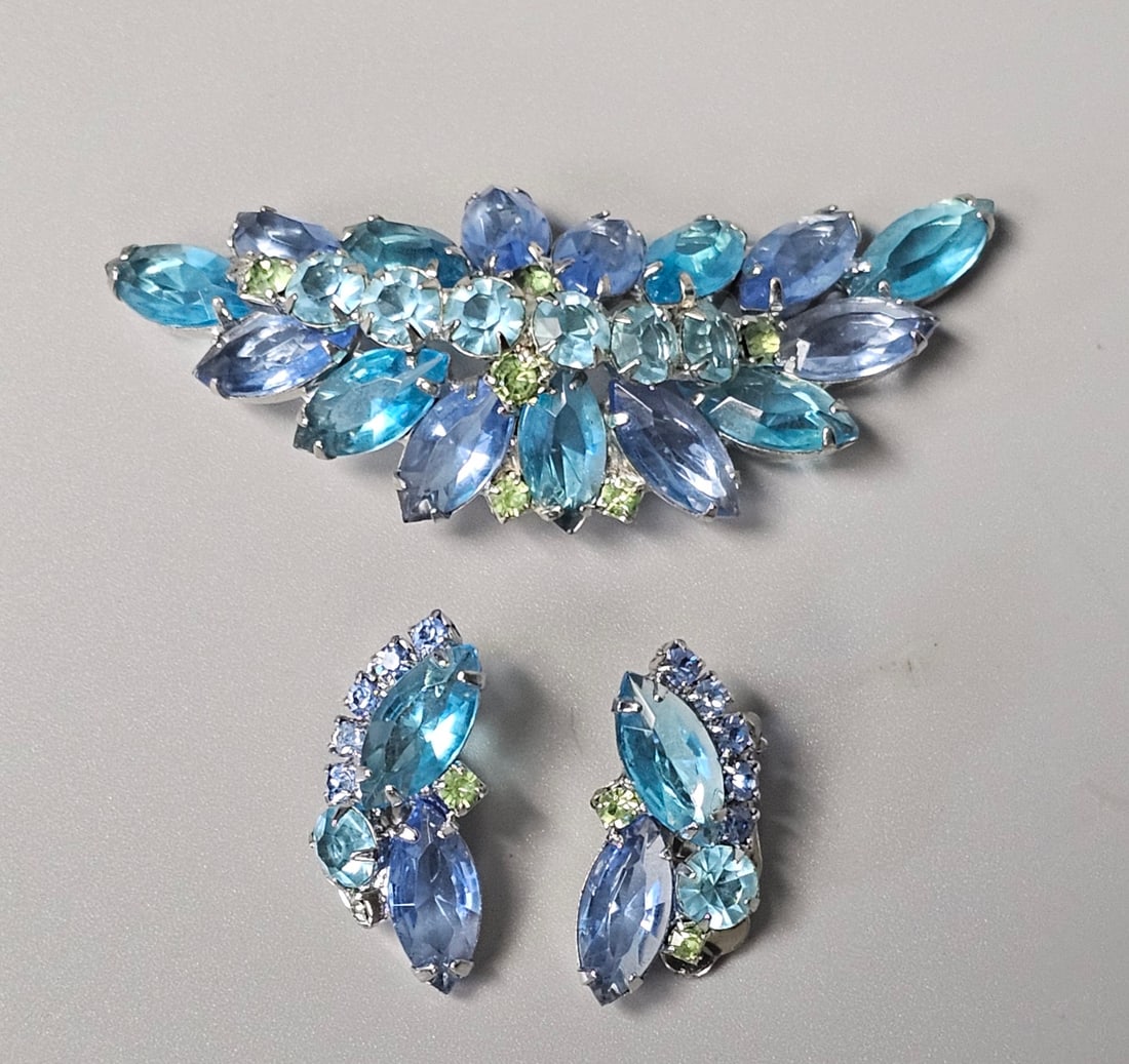 Blue & Peridot Rhinestone Brooch & Earrings: A mid-century vintage costume jewelry demi-parure featuring a matching brooch and a pair of clip-on earrings. The set is fashioned in a stylized spray motif with multi-colored faceted glass
