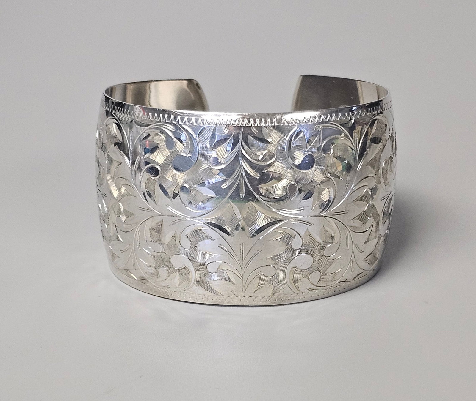 Sterling Engraved Floral Cuff 33.3 Grams: This wide Sterling cuff bracelet features elaborate hand-engraved floral and foliate scrollwork across the exterior surface. The interior of the cuff has a smooth, polished finish and is stamped with