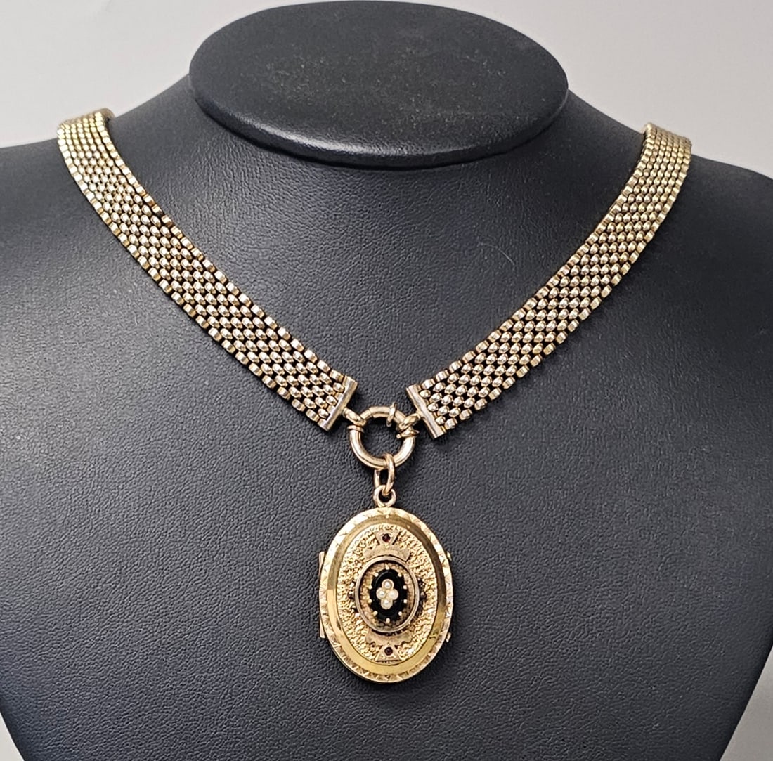 Victorian Yellow Metal Book-Chain Locket Necklace: This antique Victorian-era necklace features a wide, four-row articulated mesh book-chain collar and a matching oval locket. The locket obverse is embellished with an ornate chased and stippled