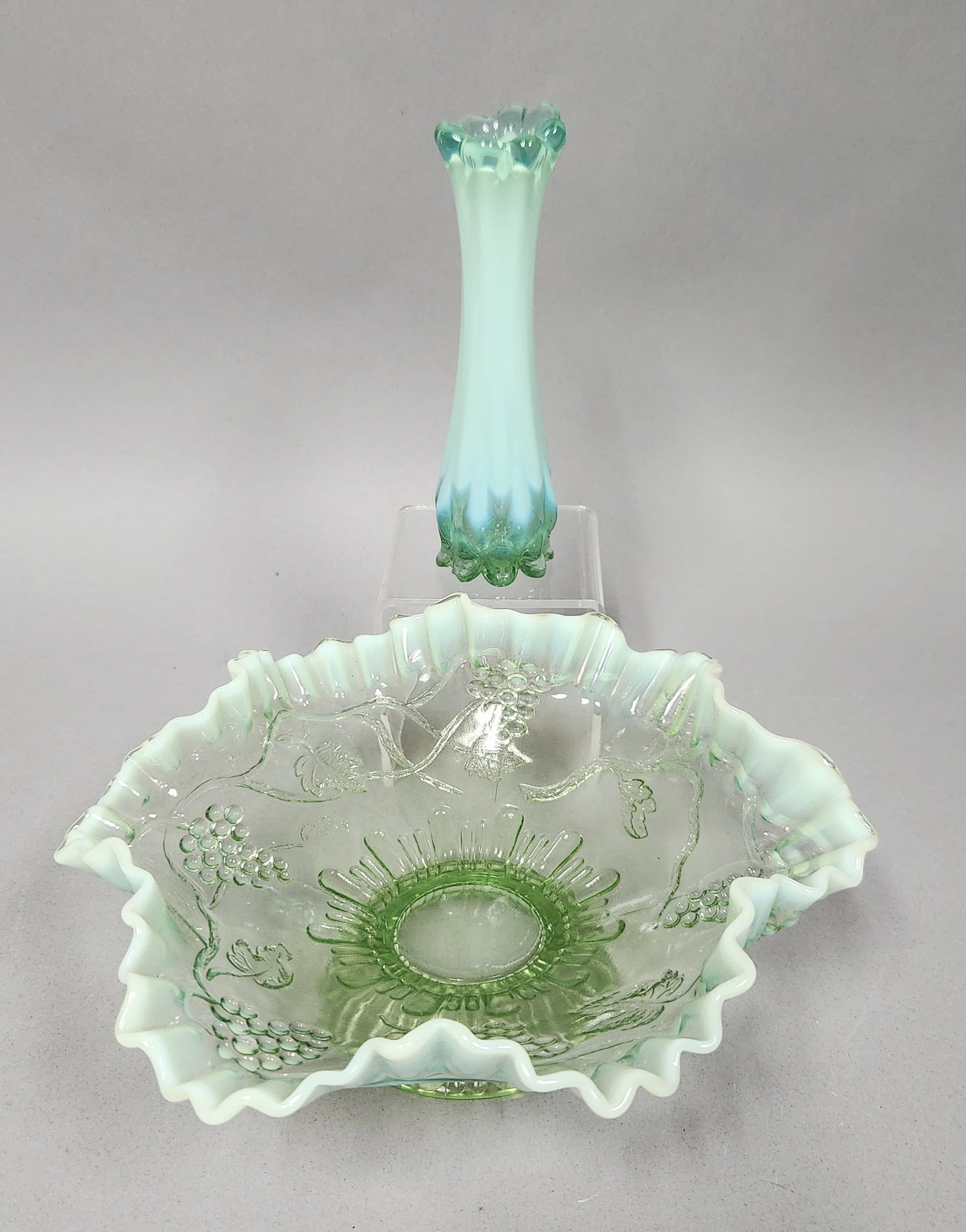 Jefferson Green Opalescent Glassware: A Jefferson Glass "Vintage" pattern bowl and a coordinating swung vase. The pressed glass bowl features embossed grape motifs and a ruffled rim, while the mold-blown vase stands on an eight-toed foote