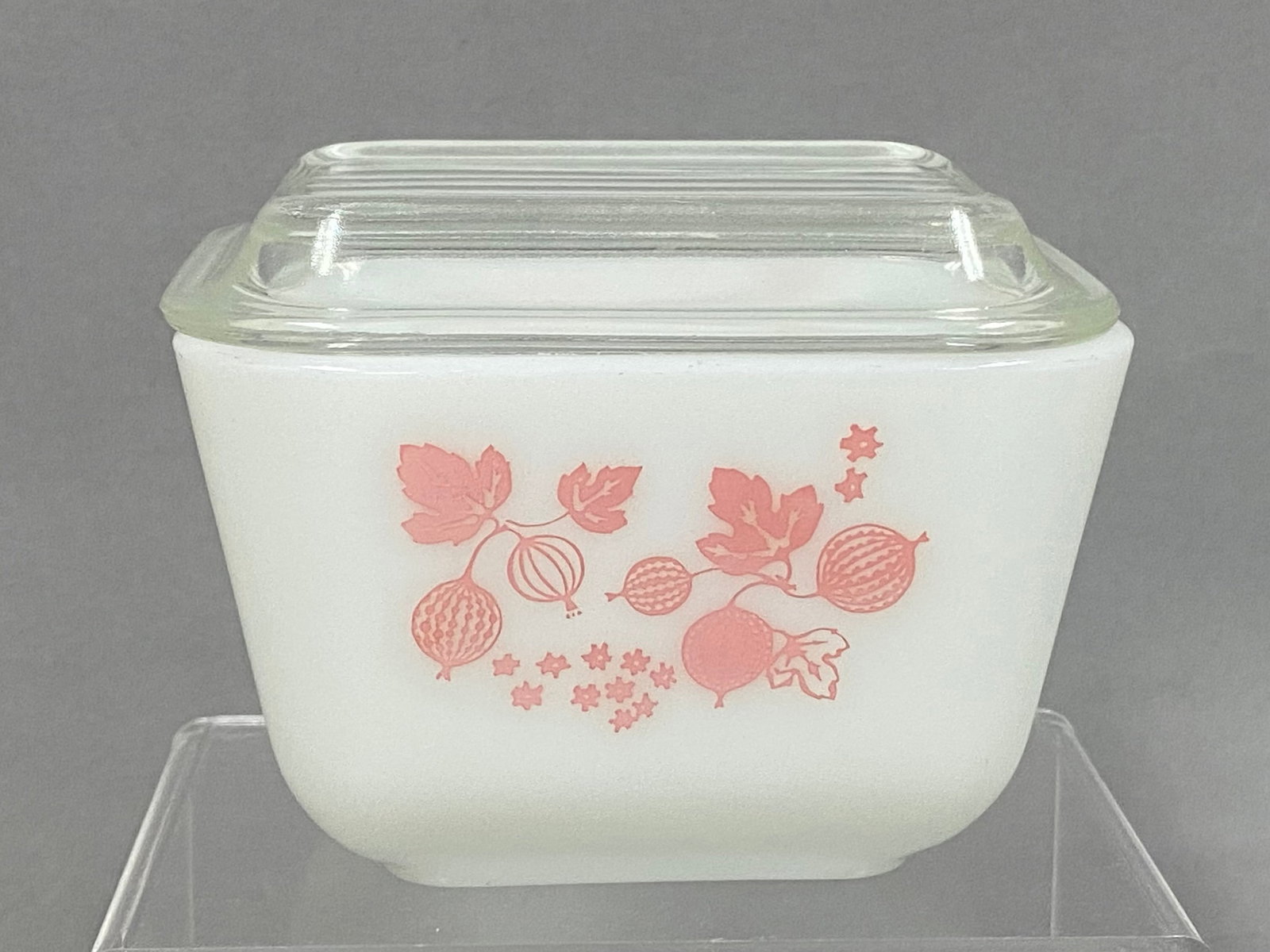 Pyrex Gooseberry Pink Glass Refrigerator Dish: A vintage American Pyrex refrigerator dish in the Gooseberry pattern. This model 501 vessel is constructed from opaque white glass and features silk-screened graphics in pink depicting clusters of goo