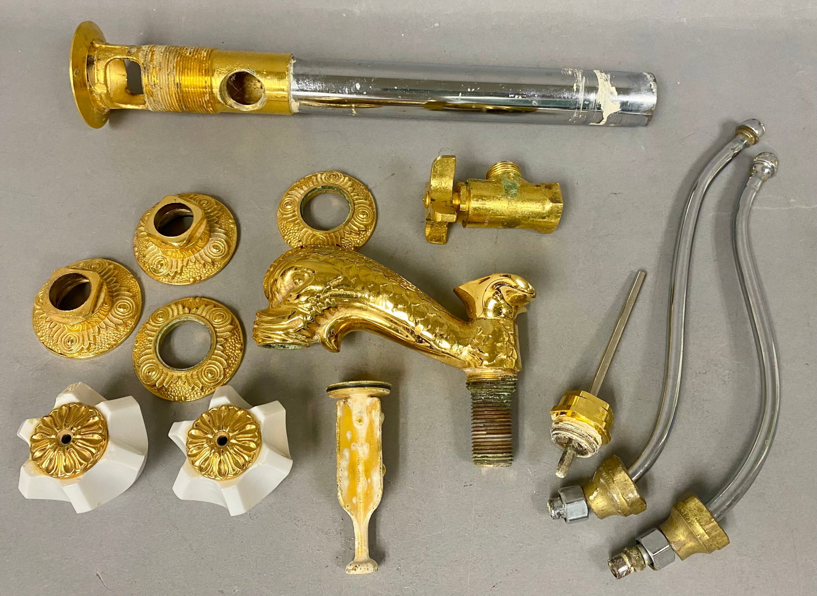 Sherle Wagner 24K Gold-Plated Dolphin Faucet: A vintage disassembled widespread bathroom sink faucet set featuring a central spout cast in the form of a stylized maritime dolphin. The set is constructed from cast brass with a gold-tone gilded
