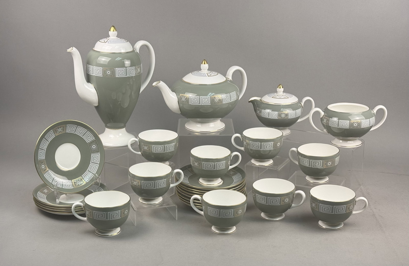 Wedgwood Asia Green Bone China Set: A Wedgwood Asia pattern bone china tea and coffee service featuring sage green grounds decorated with white Greek key borders and gold sunburst motifs. This set of 24 pieces includes a coffee pot, tea
