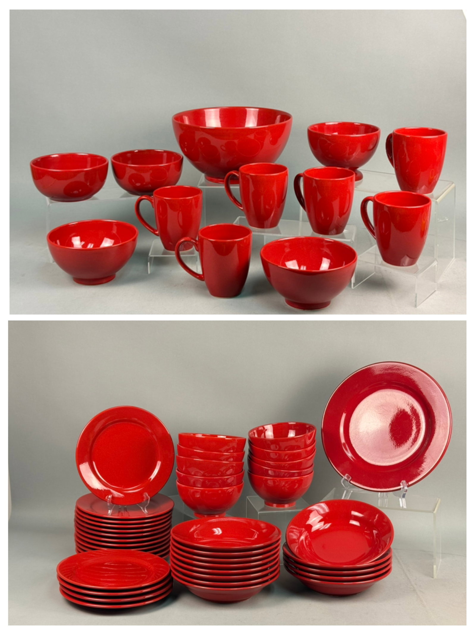 Large Red Glazed Stoneware Dinnerware Set: An extensive assortment of contemporary stoneware dinnerware featuring a vibrant high-gloss red reactive glaze. The collection includes various plates, bowls, and mugs characterized by simple rounded